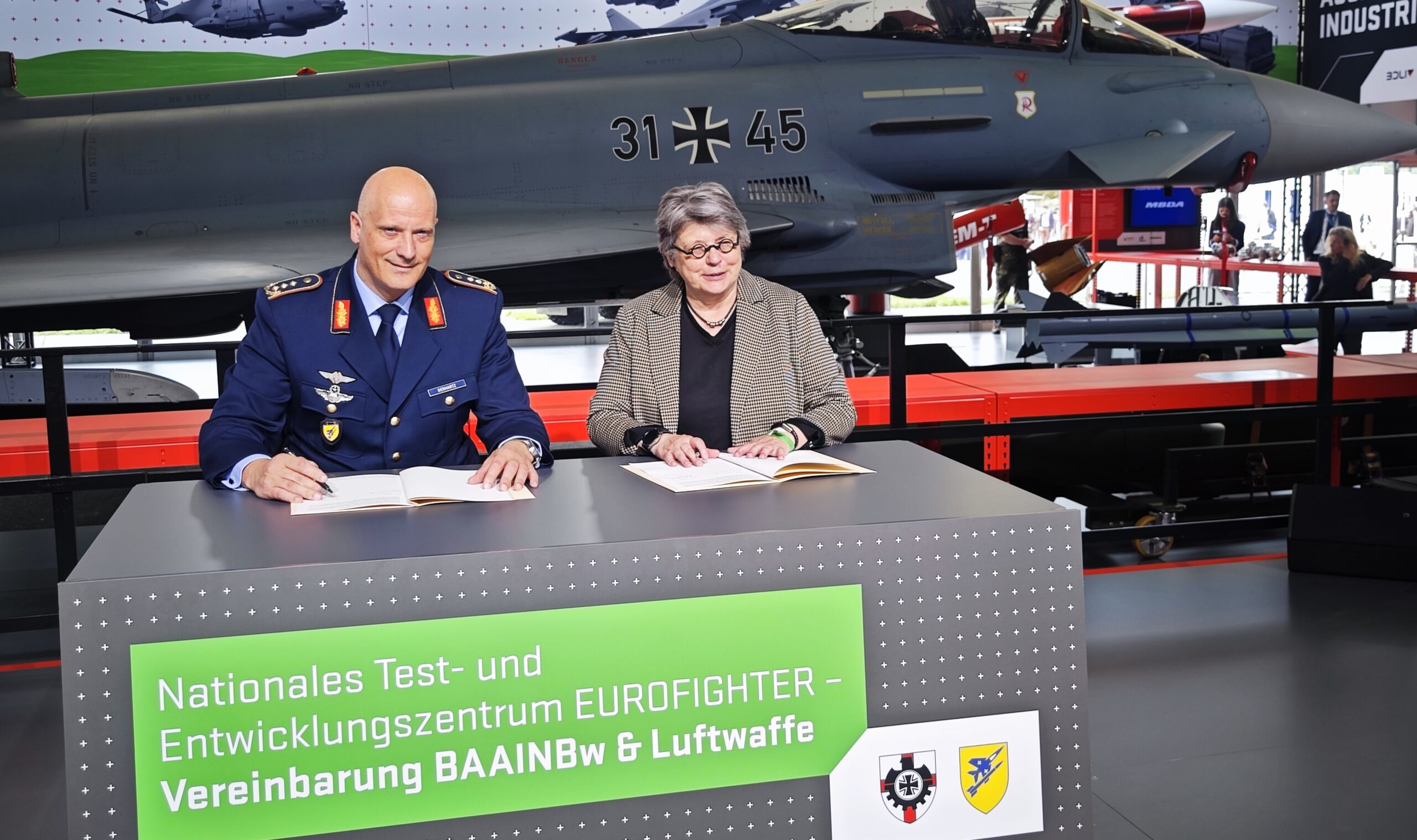 Die Präsidentin des BAAINBw, Annette Lehnigk-Emden, und der Inspekteur der Luftwaffe, Generalleutnant Ingo Gerhartz, unterzeichnen auf der ILA 2024 die Zusammenarbeitsvereinbarung