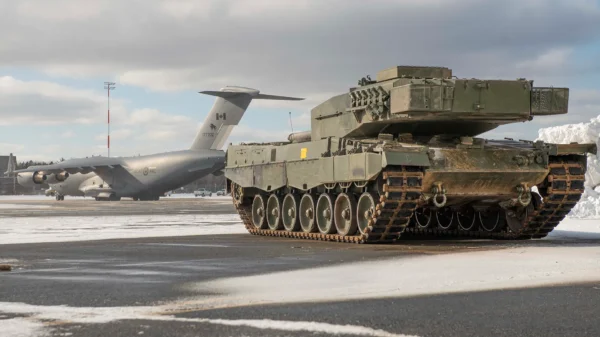 Kampfpanzer bereit zum Verladen und Weitertransport durch die auf dem Rollfeld wartende Boeing C-17 Globemaster der Royal Canadian Air Force.