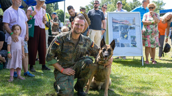 Ein Soldat posiert mit seinem Diensthund am Tag der Bundeswehr 2022 in Warendorf.
