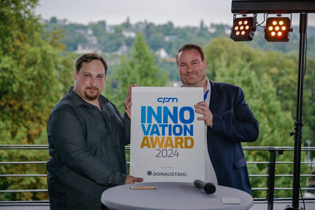 Stefan Thumann, Geschäftsführer der Donaustahl GmbH, nimmt auf der RÜ.NET den cpm Innovation Award von Tobias Ehlke, Geschäftsführer der cpm GmbH (v.l.n.r.), entgegen.