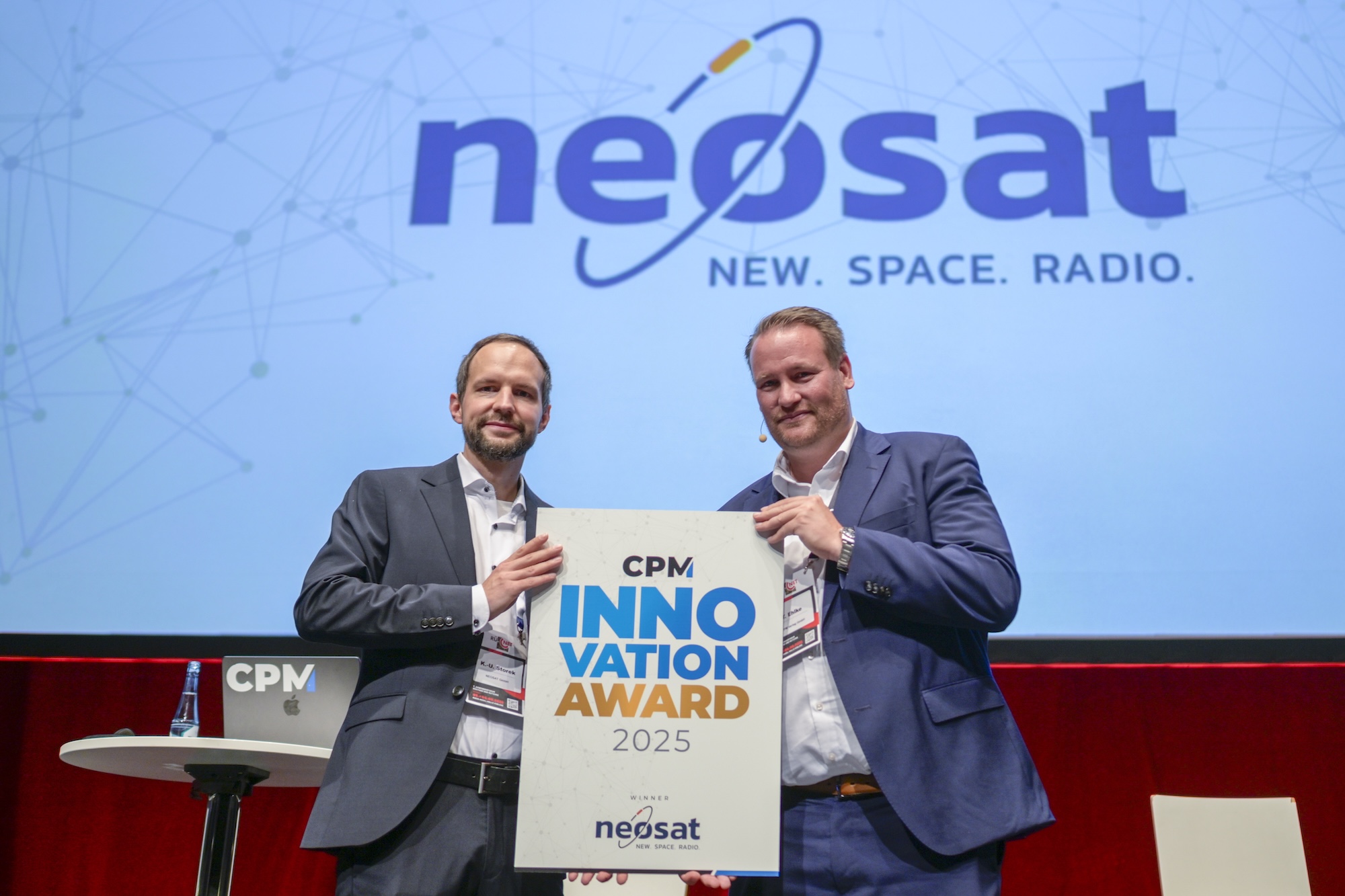 Der Geschäftsführer von NEOSAT, Kai-Uwe Storek (l.), nimmt die Auszeichnung Innovation Award von CPM-Geschäftsführer Tobias Ehlke entgegen.