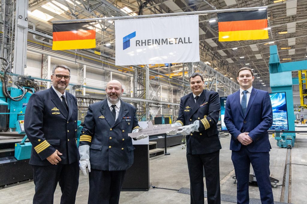 Brennbeginn für das dritte Flottendienstboot FDB 424 am 16. April 2026 auf der Peene-Werft. Von links: Kapitän z. S. Dietrich Esfeld, Projektleiter für das FDB 424, Fregattenkapitän Omar de Stefano, Fregattenkapitän Peter W. und Florian Lahl, Rheinmetall-Projektleiter für das FDB 424