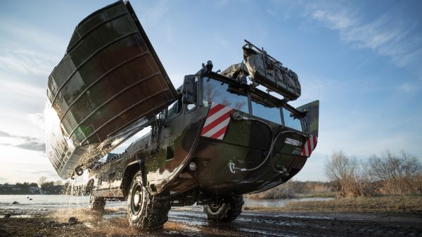 Eine Amphibie M3, der Vorgänger der neuen Schwimmschnellbrücke 2, verlässt das Gewässer und klappt ihre Seitenschwimmkörper wieder ein.