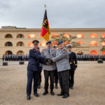Indienststellung: Das Kommando Gesundheitsversorgung der Bundeswehr wurde am 22. September 2025 offiziell in den Dienst gestellt. Besiegelung durch Händedruck Befehlshaber Unterstützungskommando, Generalleutnant Gerald Funke, Kommandeur Kommando Gesundheitsversorgung, Generalstabsarzt Dr. Johannes Backus, und Befehlshaber Zentraler Sanitätsdienst der Bundeswehr, Generaloberstabsarzt Dr. Ralf Hoffmann, vor der Truppenfahne.