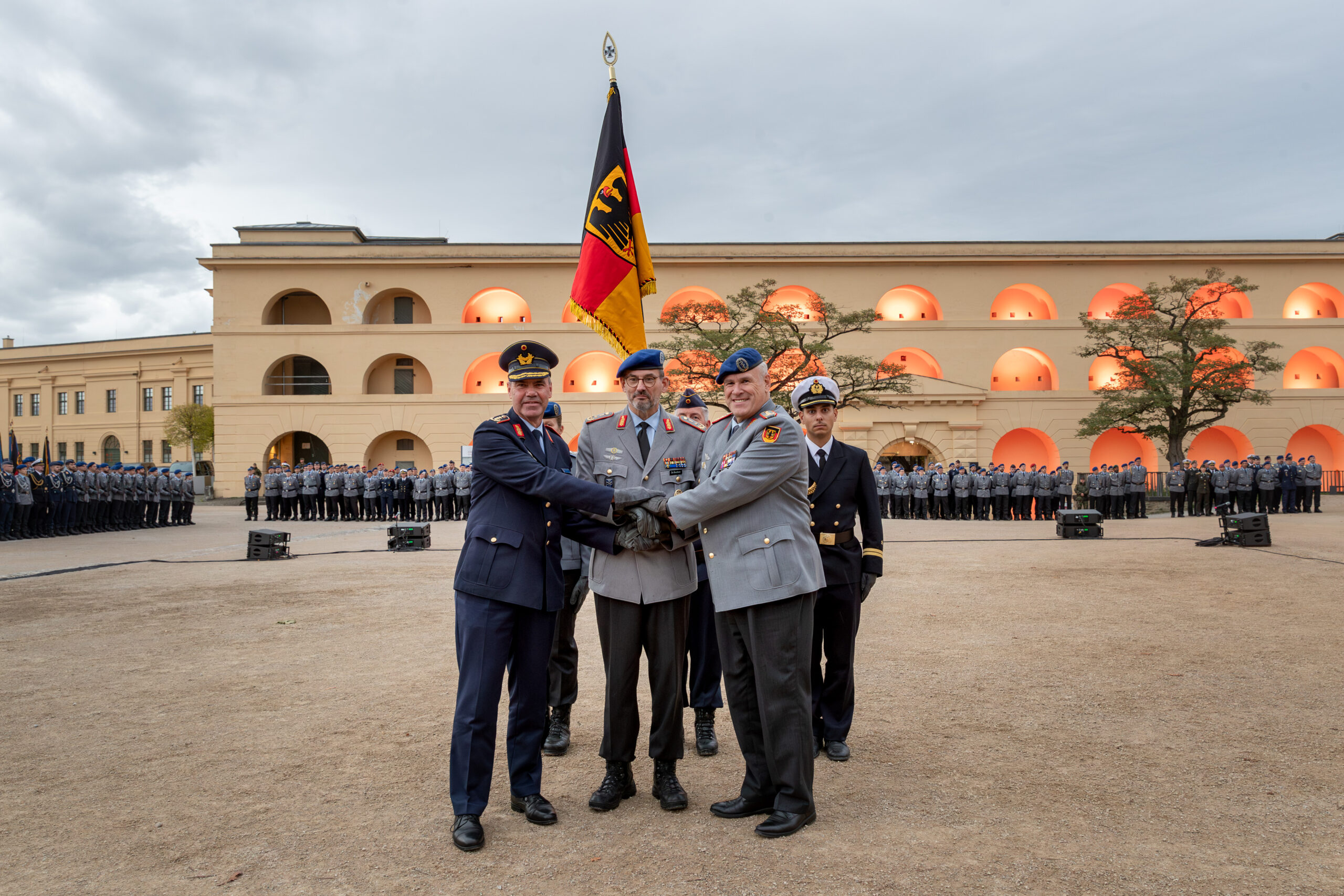 Indienststellung: Das Kommando Gesundheitsversorgung der Bundeswehr wurde am 22. September 2025 offiziell in den Dienst gestellt. Besiegelung durch Händedruck Befehlshaber Unterstützungskommando, Generalleutnant Gerald Funke, Kommandeur Kommando Gesundheitsversorgung, Generalstabsarzt Dr. Johannes Backus, und Befehlshaber Zentraler Sanitätsdienst der Bundeswehr, Generaloberstabsarzt Dr. Ralf Hoffmann, vor der Truppenfahne.