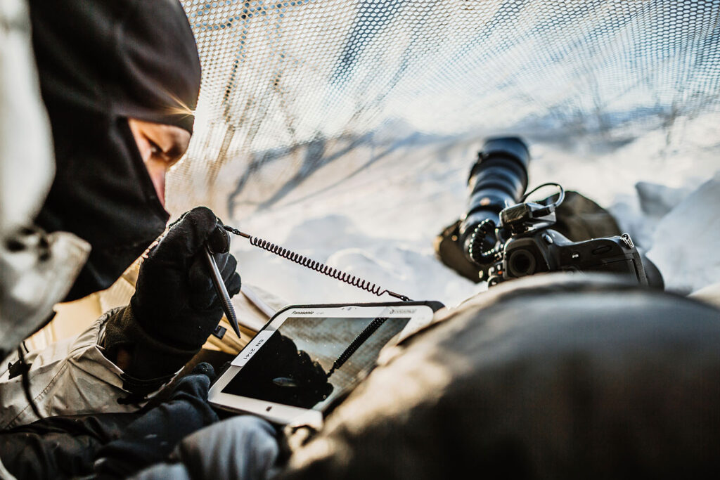 Ein Fernspäher der Luftlandebrigade 1 übermittelt im Beobachtungs- versteck Daten bei der Übung Cold Response im arktischen Gelände am Polarkreis in Norwegen. Foto: Bundeswehr / Jana Neumann