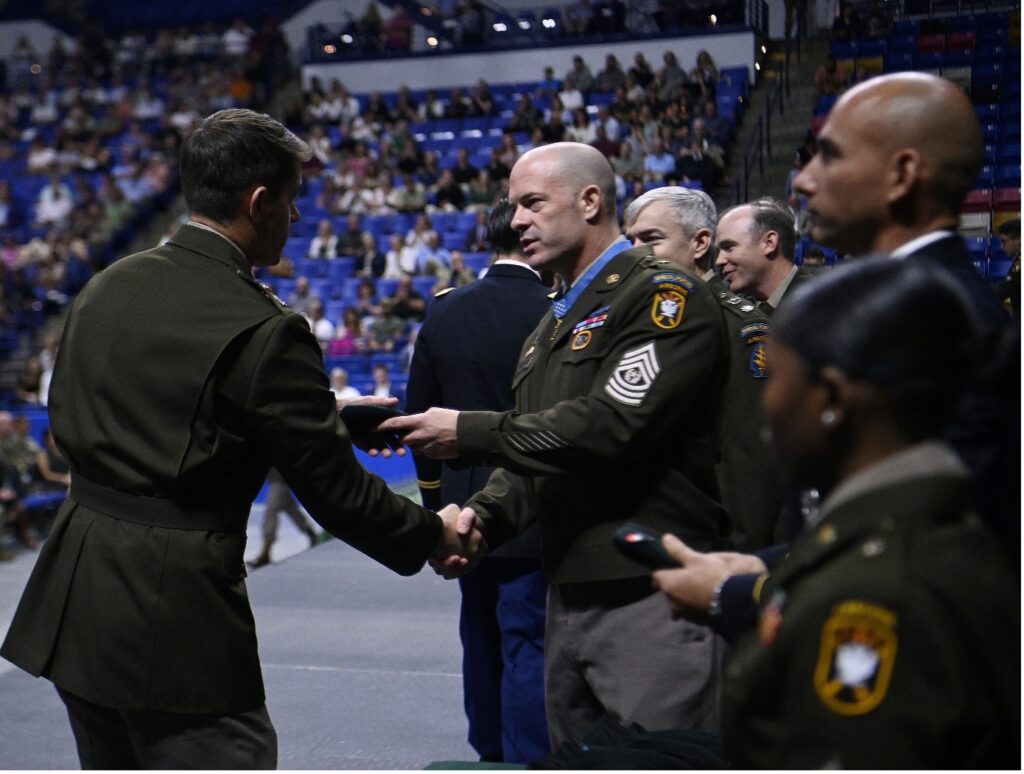 Command Sgt. Maj. Matthew O. Williams, Träger der Medal of Honor des John F. Kennedy Special Warfare Center and School der US-Armee, überreicht einem Studenten während einer Abschlussfeier und der ersten Regimentsformation ein Green Berets. (Alle Fotos: U.S. Army)