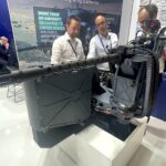 Die neue Waffenstation External Mount Gun System (EMGS) von FN Herstal verbindet im Prinzip die Eigenschaften einer Doorgunner-bedienten Pintle-Waffenstation mit der eines ferngesteuerten Pods. Oben trägt sie eine Optik für bessere Trefferergebnisse auf große Entfernungen.
