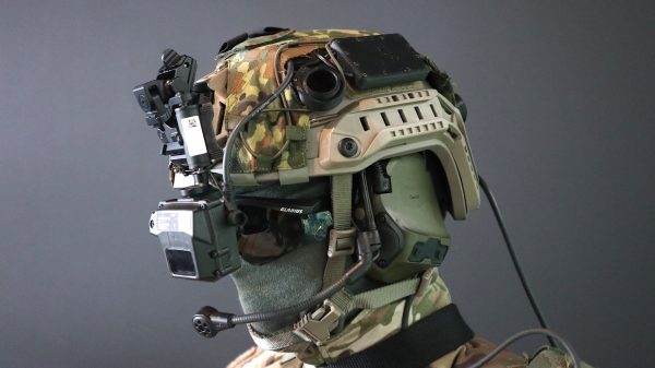 Der "Infanterist der Zukunft" trägt eine Menge digitaler Unterstützung: Um den Gefechtshelm mit Tarnbezug finden sich ein aktiver Gehörschutz samt Mikrofon, Laser-Warngerät und ein Head-up-Display THEA von THEON.