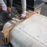 Der Mitarbeiter von Urban Industries spannt eine zuvor gebogene Panzerstahlplatte ein, dann kann sie von allen Seiten mit der Fräse bearbeitet werden.