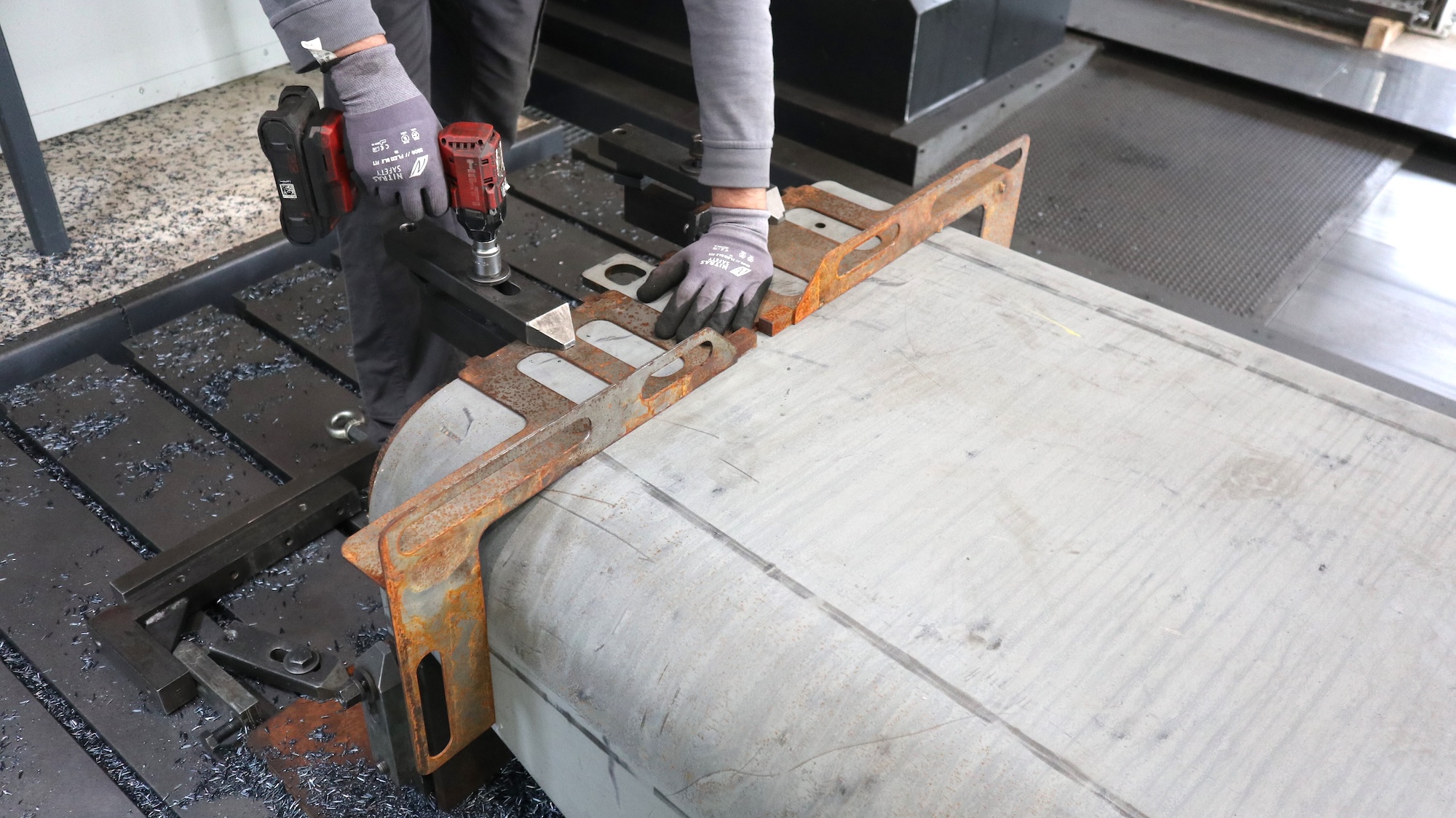 Der Mitarbeiter von Urban Industries spannt eine zuvor gebogene Panzerstahlplatte ein, dann kann sie von allen Seiten mit der Fräse bearbeitet werden.
