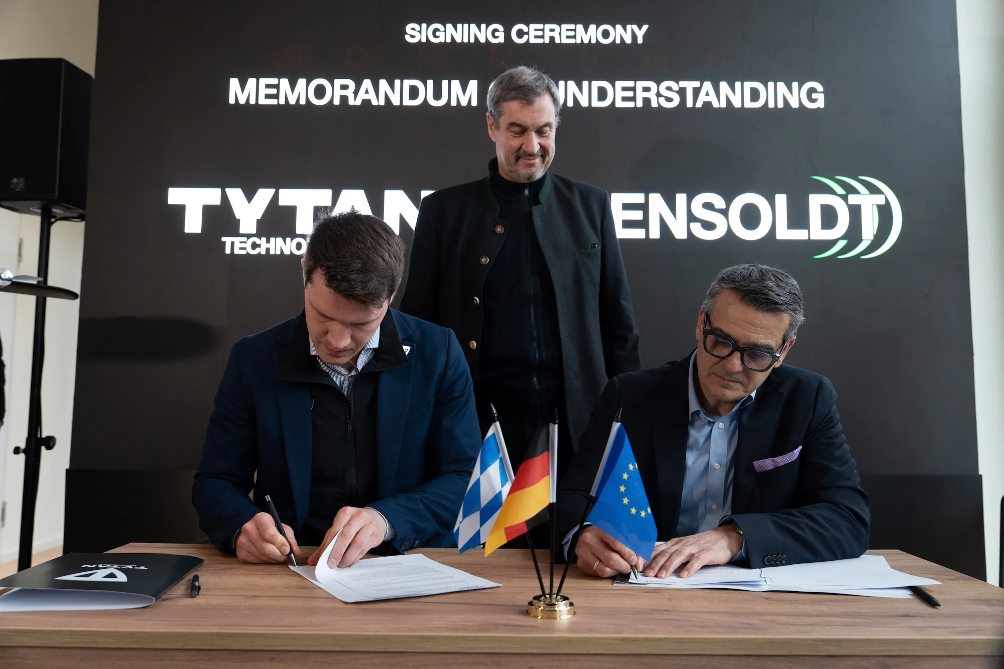 Die Vereinbarung wurde von TYTAN-CEO Balázs Nagy (l.) und HENSOLDT-CEO Oliver Dörre (r.) im Beisein von Bayerns Ministerpräsident Dr. Markus Söder (m.) in München unterzeichnet.