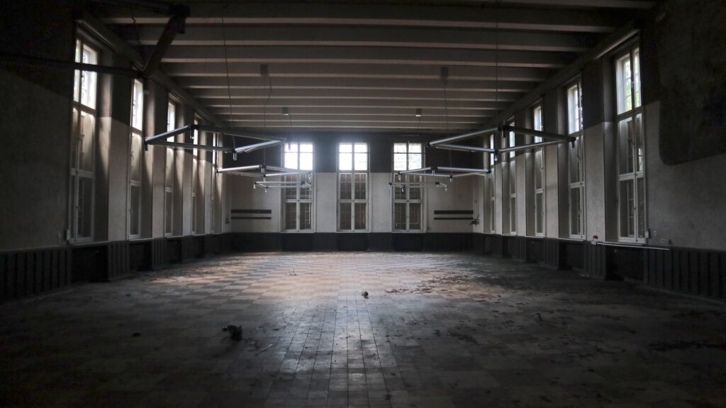 Blick in den Speisesaal. Es ist düster, da die großen Fenster zum eigenen Schutz mit Holzplatten abgedeckt wurden.