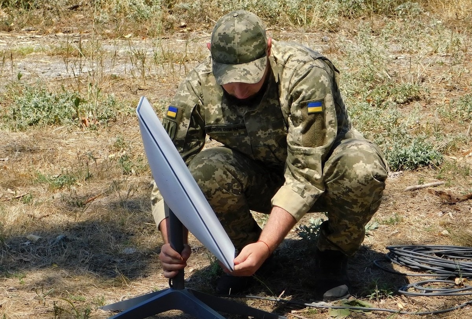 Ein ukrainischer Soldat baut ein Starlink-Terminal auf.